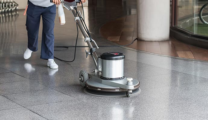 A professional commercial floor cleaning machine being used to clean a floor.