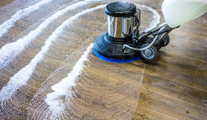 cleaning wooden floor using a floor scrubber