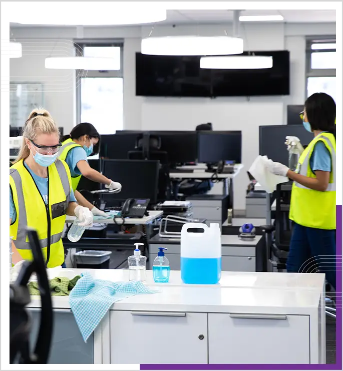 A professional team, cleaning office desks and computers.