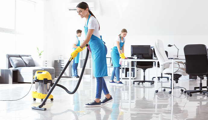 A person engaged in post-construction cleanup, using an industrial vacuum cleaner