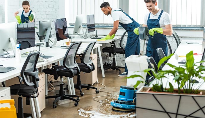 An office room is being cleaned by professional cleaners.